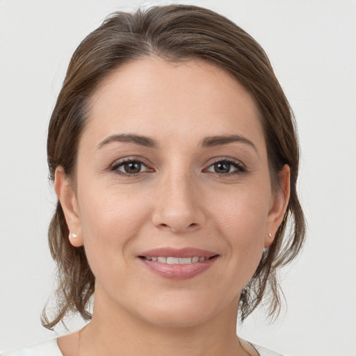 Joyful white young-adult female with medium  brown hair and grey eyes