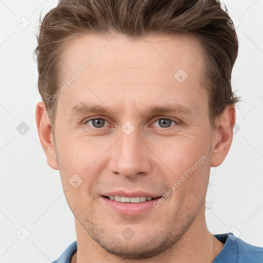 Joyful white young-adult male with short  brown hair and grey eyes