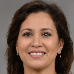 Joyful white adult female with long  brown hair and brown eyes