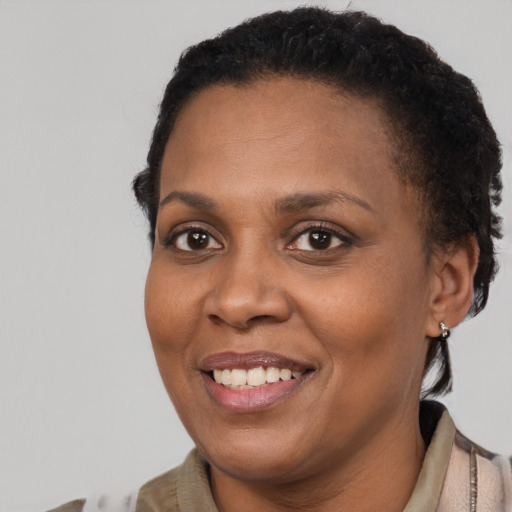 Joyful black young-adult female with short  brown hair and brown eyes