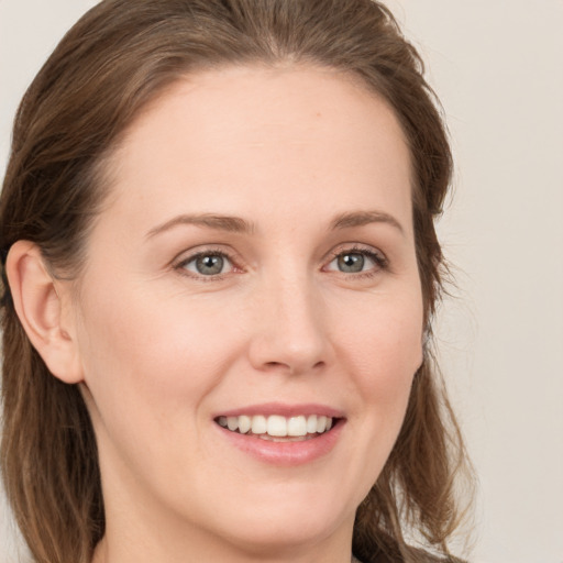 Joyful white young-adult female with long  brown hair and grey eyes