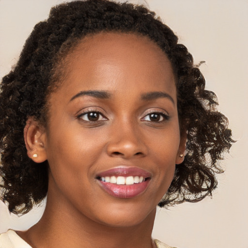 Joyful black young-adult female with medium  brown hair and brown eyes