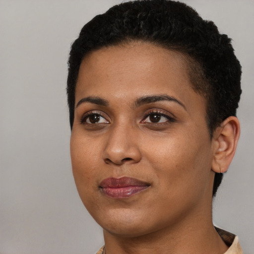 Joyful black young-adult female with short  black hair and brown eyes