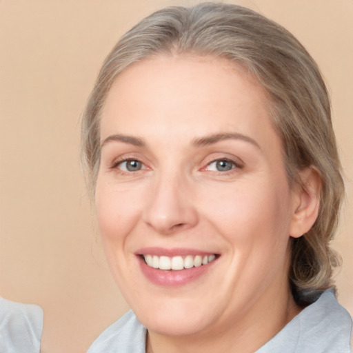 Joyful white adult female with medium  brown hair and blue eyes