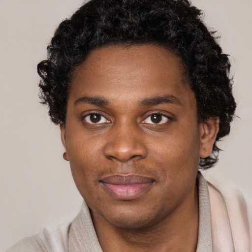Joyful black young-adult male with short  black hair and brown eyes