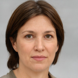 Joyful white adult female with medium  brown hair and grey eyes