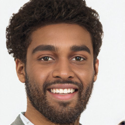 Joyful black young-adult male with short  brown hair and brown eyes