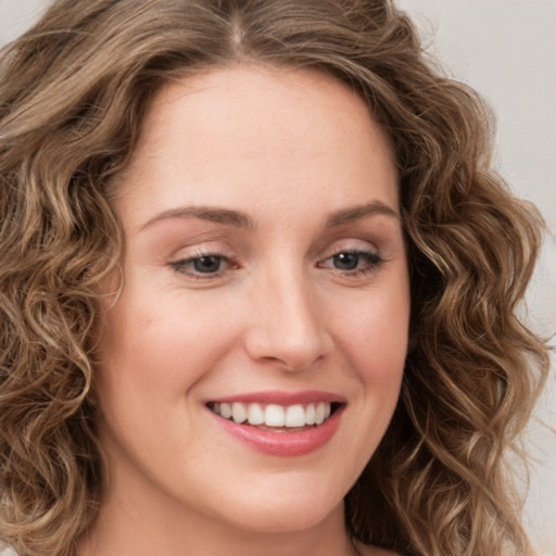 Joyful white young-adult female with long  brown hair and green eyes