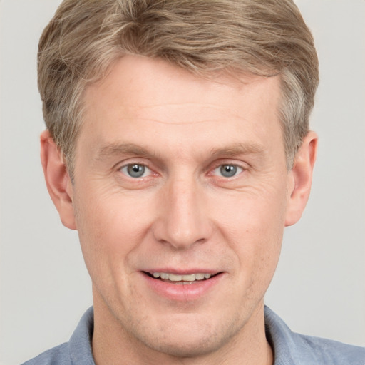 Joyful white adult male with short  brown hair and grey eyes