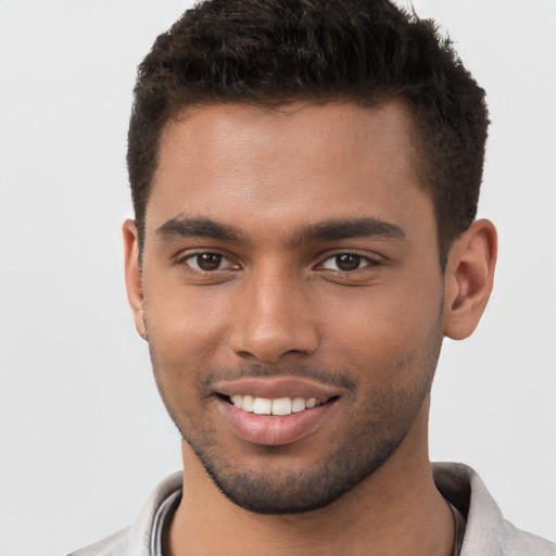 Joyful black young-adult male with short  brown hair and brown eyes