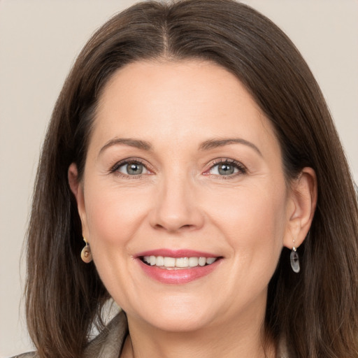 Joyful white adult female with long  brown hair and grey eyes