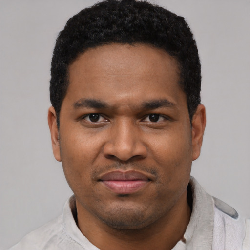 Joyful black young-adult male with short  black hair and brown eyes