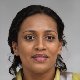 Joyful black adult female with long  brown hair and brown eyes