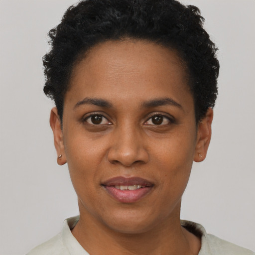 Joyful black young-adult female with short  black hair and brown eyes