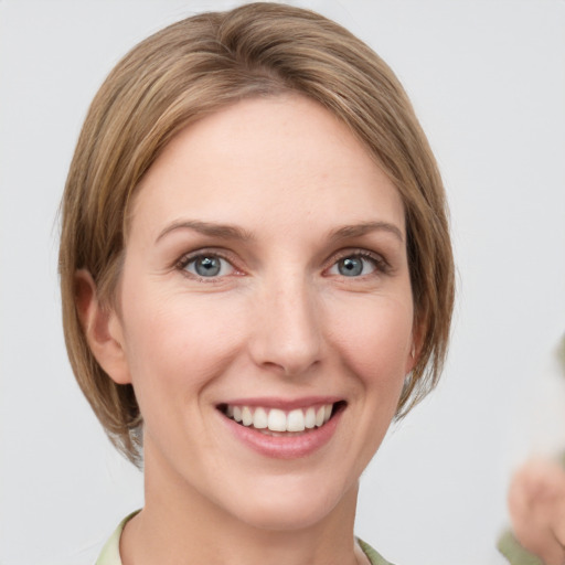 Joyful white young-adult female with medium  brown hair and grey eyes