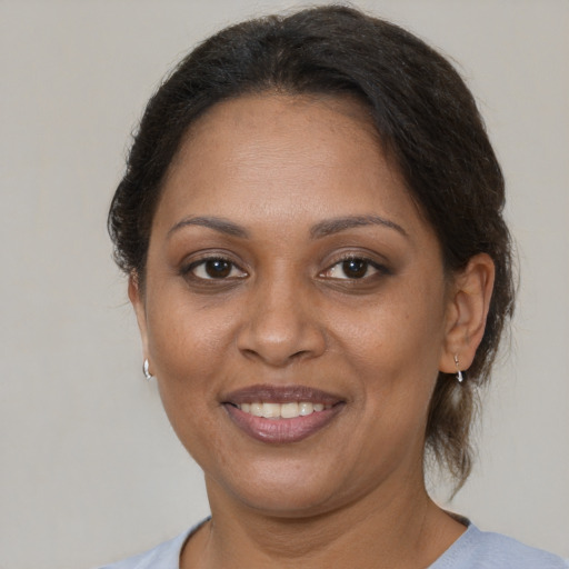 Joyful black adult female with medium  brown hair and brown eyes