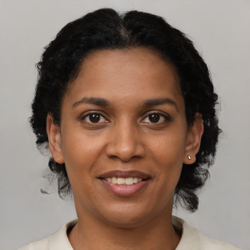 Joyful black young-adult female with short  brown hair and brown eyes