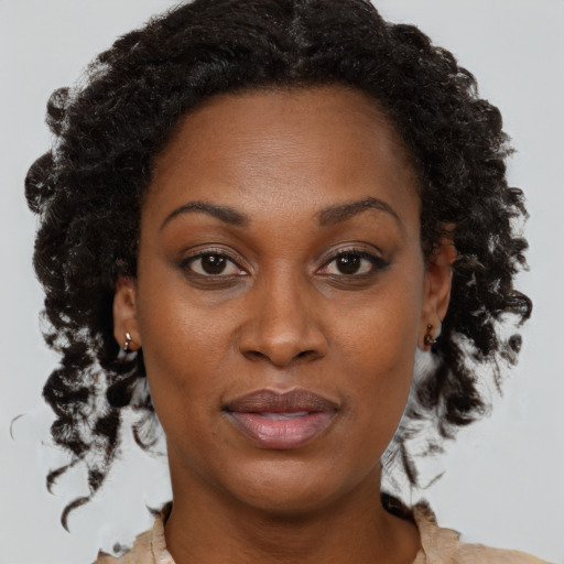 Joyful black adult female with medium  brown hair and brown eyes