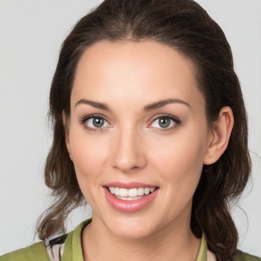 Joyful white young-adult female with medium  brown hair and green eyes