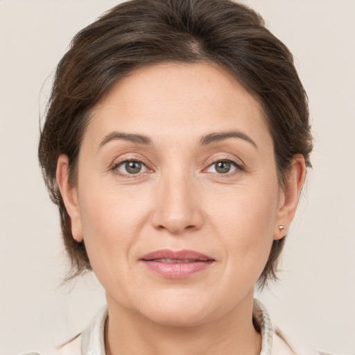 Joyful white adult female with medium  brown hair and grey eyes