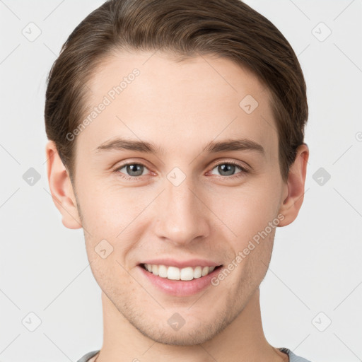 Joyful white young-adult male with short  brown hair and grey eyes