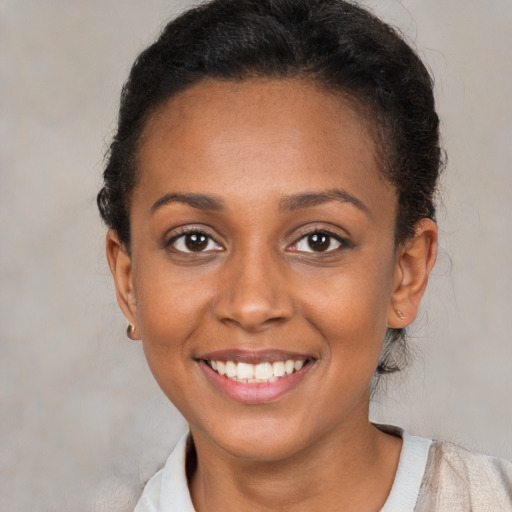 Joyful black young-adult female with short  brown hair and brown eyes