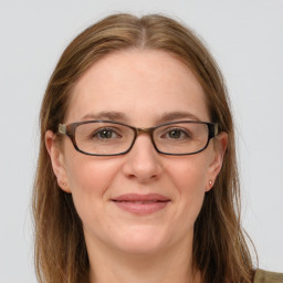 Joyful white adult female with long  brown hair and grey eyes