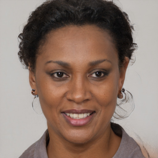 Joyful black adult female with short  brown hair and brown eyes