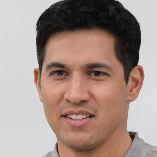 Joyful white young-adult male with short  black hair and brown eyes