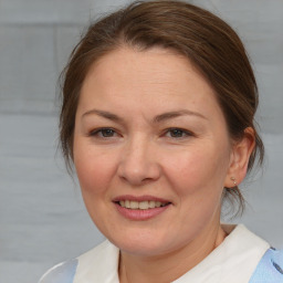 Joyful white adult female with medium  brown hair and blue eyes