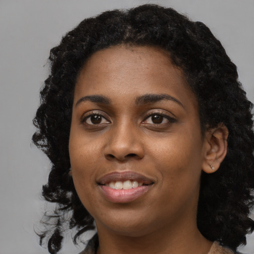 Joyful black young-adult female with long  black hair and brown eyes