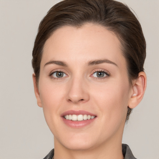 Joyful white young-adult female with short  brown hair and grey eyes