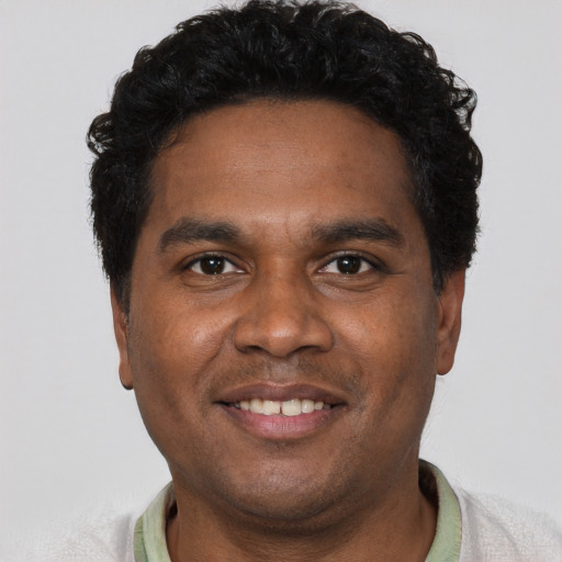 Joyful black young-adult male with short  black hair and brown eyes