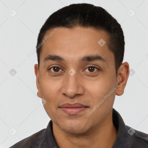 Joyful latino young-adult male with short  black hair and brown eyes