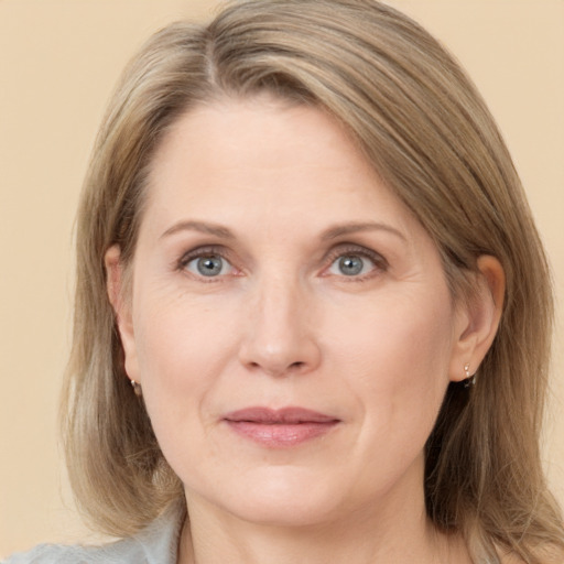 Joyful white adult female with medium  brown hair and grey eyes