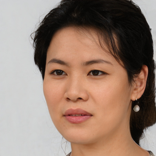 Joyful asian young-adult female with medium  brown hair and brown eyes