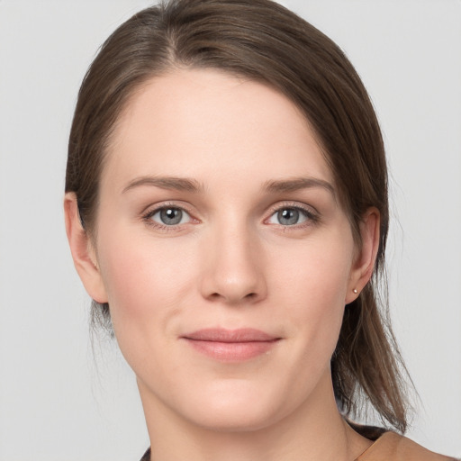 Joyful white young-adult female with medium  brown hair and grey eyes