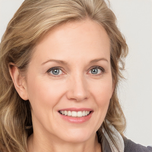 Joyful white adult female with medium  brown hair and blue eyes