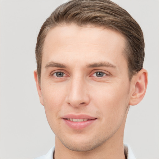 Joyful white young-adult male with short  brown hair and grey eyes