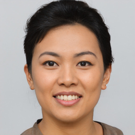 Joyful asian young-adult female with short  brown hair and brown eyes