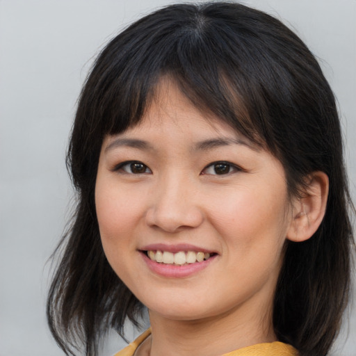Joyful asian young-adult female with medium  brown hair and brown eyes