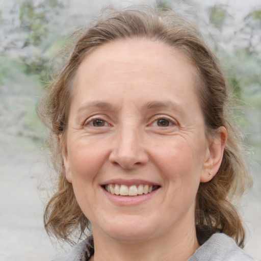 Joyful white adult female with medium  brown hair and blue eyes