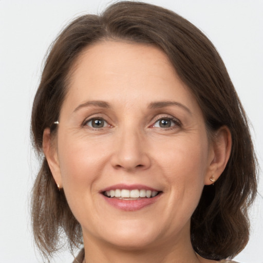 Joyful white adult female with medium  brown hair and grey eyes