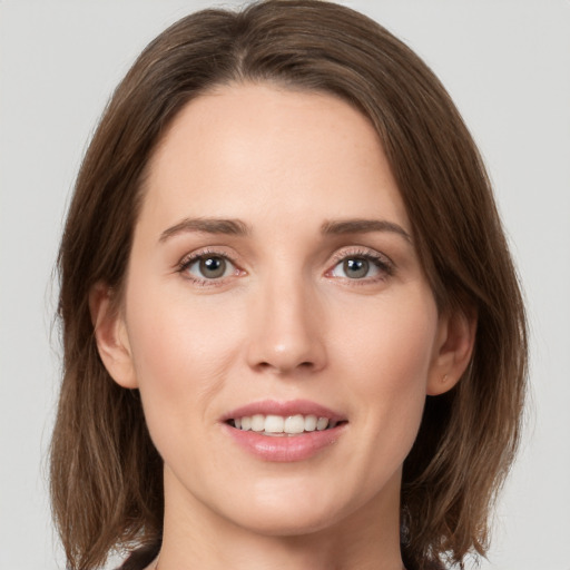 Joyful white young-adult female with medium  brown hair and green eyes