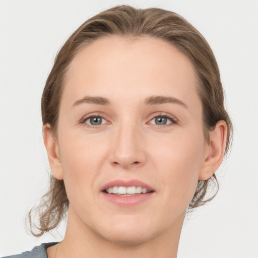 Joyful white young-adult female with medium  brown hair and grey eyes