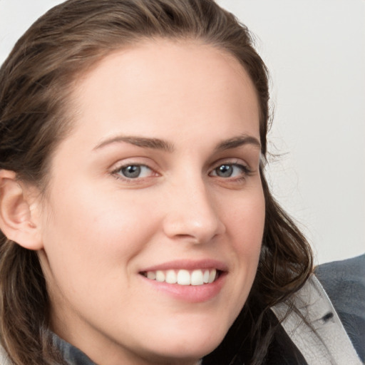 Joyful white young-adult female with long  brown hair and blue eyes