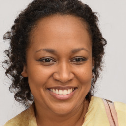 Joyful black adult female with long  brown hair and brown eyes