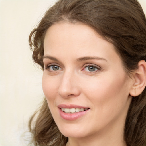 Joyful white young-adult female with medium  brown hair and green eyes