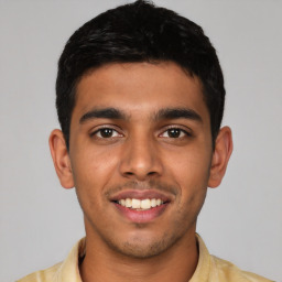 Joyful latino young-adult male with short  black hair and brown eyes