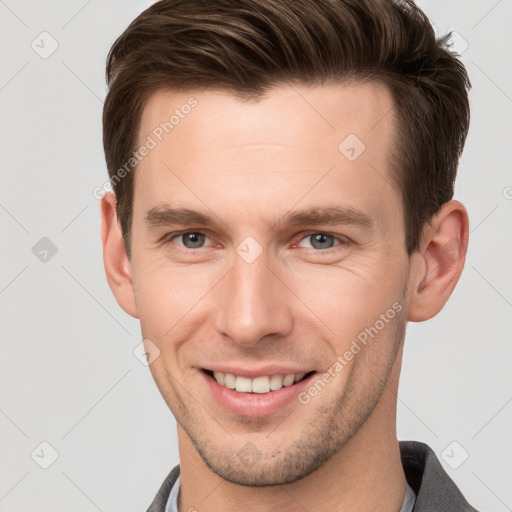 Joyful white young-adult male with short  brown hair and grey eyes